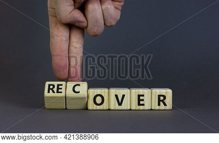 Time To Recover Symbol. Businessman Turns Wooden Cubes And Changes The Word 'over' To 'recover'. Bea