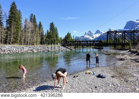 Canmore, Alberta, Canmore - May 15th, 2021: A Group Of People Enjoying The Shores Of The Bow River S