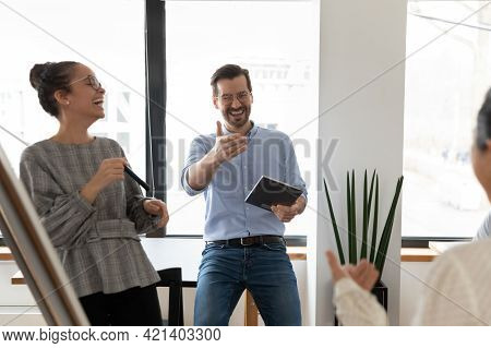 Overjoyed Diverse Colleagues Having Fun At Meeting, Laughing At Joke