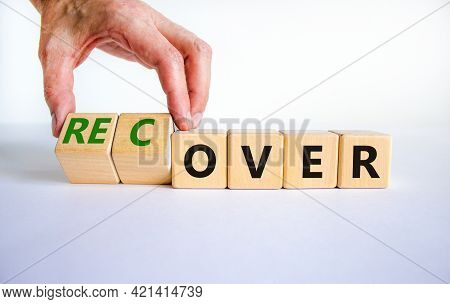 Time To Recover Symbol. Businessman Turns Wooden Cubes And Changes The Word 'over' To 'recover'. Bea
