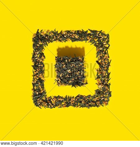Japanese Green Tea Genmaicha. Tea Leaves With Fried Brown Rice In The Shape Of A Cube On A Bright Ye