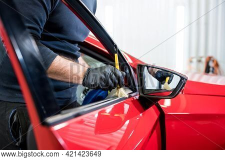 Car Service Worker Cleans Interiror With Special Brush