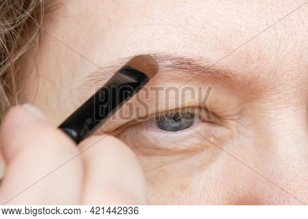 Middle-aged Woman Does Corrective Eye Makeup To Correct The Drooping Eyelid. Ptosis Is A Drooping Of