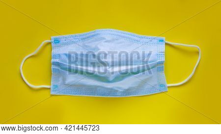 Blue Mask From Coronavirus On Yellow Background