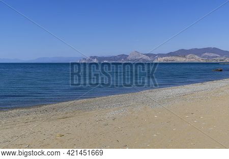 Calm Sea And Empty Sandy Beach In Kapsel Bay At The Foot Of Cape Meganom, View Towards Sudak. . Off-