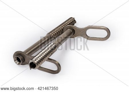 Two Modern Tubular Titanium Ice Screws With Carabiners Eyelets For Ice Climbing On A White Backgroun