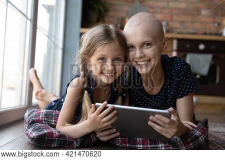 Happy Ill Hairless Young Mother And Pre Teen Daughter