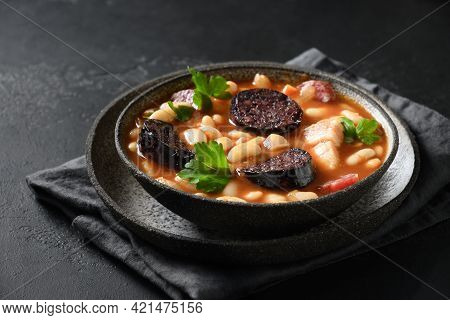 Spanish Asturiana Fabada With Chorizo And Morcilla On Black Background.