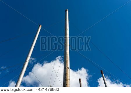Unused Industrial Chimnies Against Perfect Blue Sky With White Clouds.