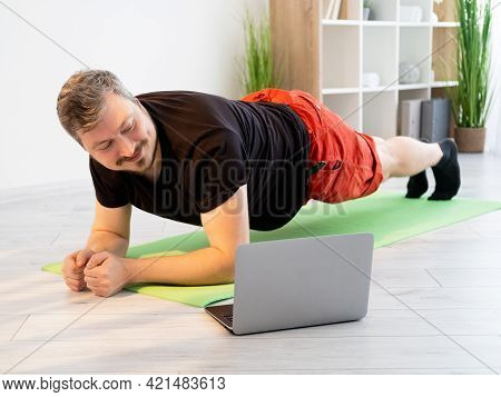 Fitness Video Training. Sportive Man. Home Gym. Healthy Body. Static Workout. Smiling Guy In T-shirt