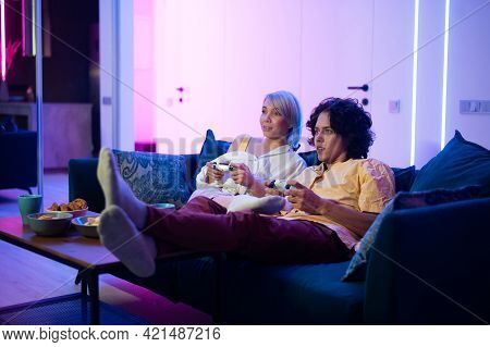 Couple Playing Videogame On Console. Girl Losing And Not Letting The Guy Play Normally By Closing Hi