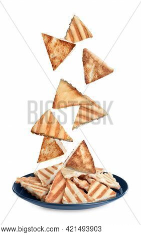 Delicious Crispy Pita Chips Falling Into Plate On White Background