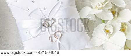 Banner With White Pillow For Wedding Rings With Rings And Rhinestone Hearts Near White Orchid On A W