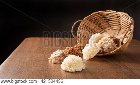 Cocada, Coconut Candy From Brazil, White And Brown Cocadas Fallen From A Straw Basket On Wooden Surf