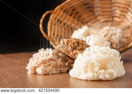 Cocada, Coconut Candy From Brazil, White And Brown Cocadas Fallen From A Straw Basket On Wooden Surf