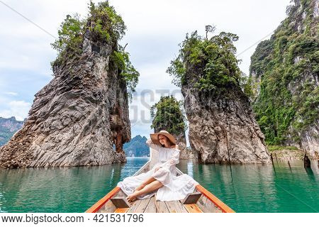 Young Female Tourist In Dress And Hat At Longtail Boat Near Famous Three Rocks With Limestone Cliffs