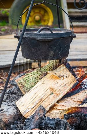 Cooking Food In A Cauldron Over Campfire In English Countryside