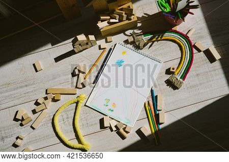 Rainbow Of Thread And Rope And Yellow Month. Children's Drawing In A Sketchbook. Cubes Are Wooden An