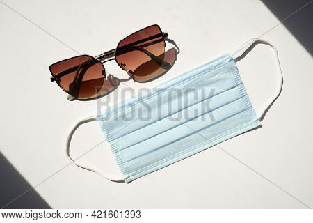 Dark Sunglasses And A Blue Face Mask