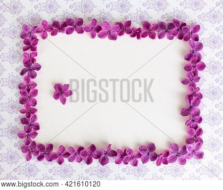 Background With Copy Space Blank On Table With Lilac Purple Flower. Violet Flowers. White Paper Top 