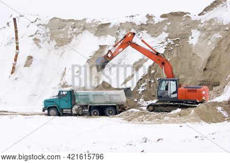Crawler Excavator In Process Of Loading Sand And Soil To Multi-ton Mining Truck.
