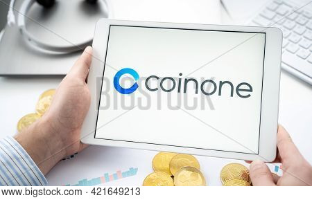 Russia Moscow 06.05.2021.businessman With Tablet.logo Of Cryptocurrency Stock Exchange Coinone.tradi