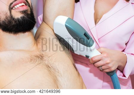 Body Care. Underarm Laser Hair Removal. Beautician Removing Hair Of Men's Armpit. In Cosmetic Beauty