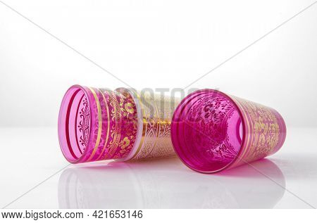 Traditional moroccan empty tea glasses or tumblers on white background. Decorative, ornamental Middle Eastern glassware product.