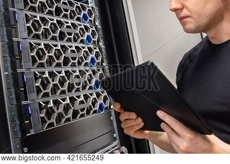 Male It Support Professional With Digital Tablet Examining Hyper Converged Server Hardware