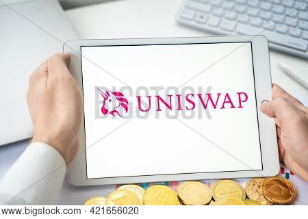 Russia Moscow 06.05.2021.businessman With Tablet.logo Of Cryptocurrency Stock Exchange Uniswap.tradi