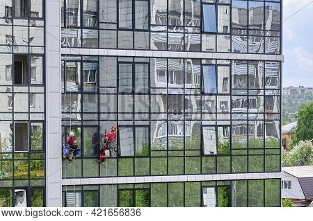 Yekaterinburg, Russia- May 10, 2020: Two Industrial Climbers From The Cleaning Service Wash The Glas