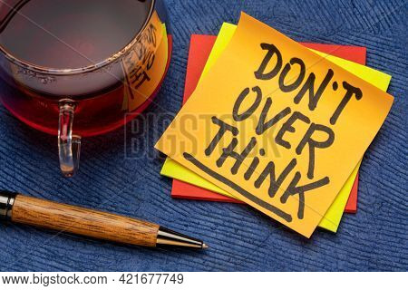 do not overthink advice or reminder - motivational handwriting on a sticky note with a cup of tea, procrastination, productivity and personal development concept