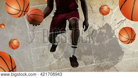 Composition of basketball player and basketballs over basketball court. sport event and competition concept digitally generated image.