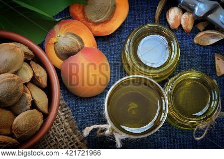 Jars Of Apricot Kernel Oil. Apricots, Leaves, Seeds.