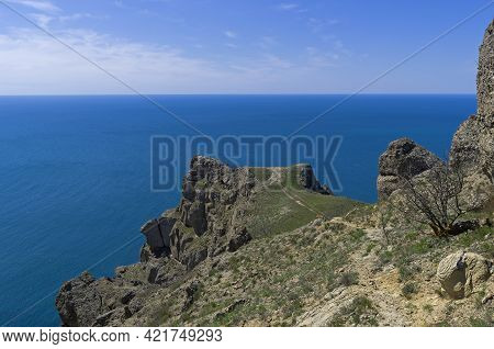 Steep Rocky Cliff Above The Sea. Cape Meganom, Crimea. Sunny Day At The End Of Apri