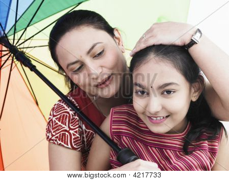 Mother And Daughter With One With Rainbow Umbrella