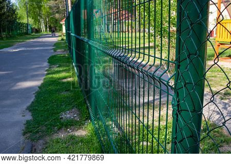Metal Fence Painted In Green Color.metal Wire Grating Along The Playground In The Park.