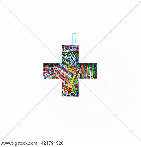Plus Summation Sign Or Cross Of Colourful Paperclips And Cut Paper Isolated On White. Typeface Of St