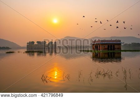 Tranquil morning at famous indian tourist landmark Jal Mahal (Water Palace) at sunrise in Jaipur. Ducks and birds around enjoy the serene morning. Jaipur, Rajasthan, India