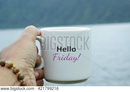 Friday Coffee. Hello Friday Greeting Text On A White Cup Of Coffee Or Tea On Blue Lake Nature Backgr