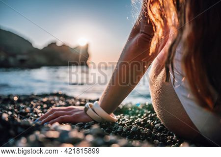 Young Woman With Long Hair In White Swimsuit And Boho Style Braclets Practicing Outdoors On Yoga Mat