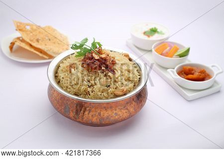 Veg Biriyani , Garnished With Fried Onion ,coriander Leaf And Fried Cashew Nut In An Antique Brass V