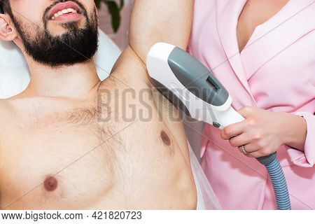 Body Care. Underarm Laser Hair Removal. Beautician Removing Hair Of Men's Armpit. In Cosmetic Beauty