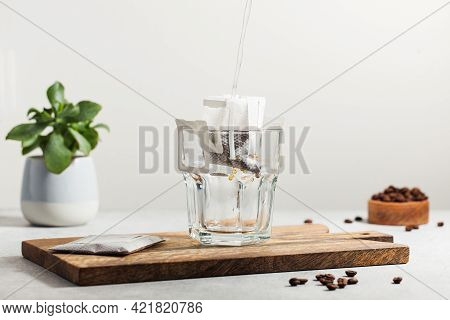 The Process Of Brewing Coffee. Water Is Poured Into A Drip Coffee Bag In A Mug. Trends In Brewing Co