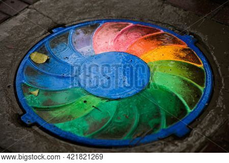 The Well, The Trapdoor On The Path, Is Painted With A Rainbow. Abstract Swirl Pattern Of Rainbow Col