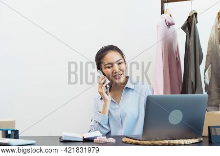 Asian Entrepreneur Is Talking To Customers Over The Phone About Their Pickup.