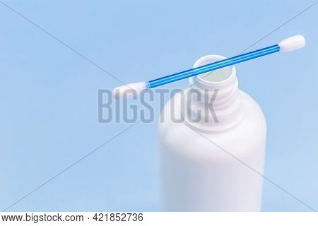Hydrogen Peroxide, In White Plastic Bottle, With Cotton Swab And Isolated Blue Background, Medicine 