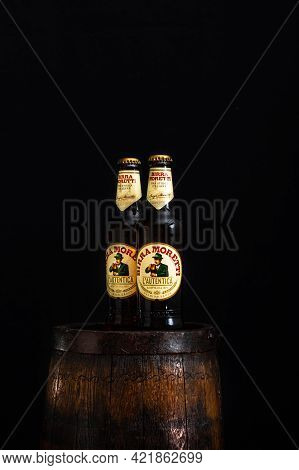 Bottle Of Birra Moretti Beer On Wooden Barrel With Dark Background. Illustrative Editorial Photo Buc