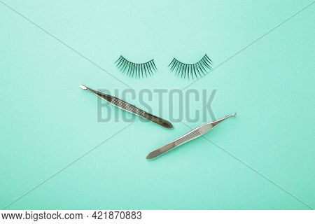 Set Of False Eyelashes Extencions On Mint Background With Tweezers. Minimalism. Top View
