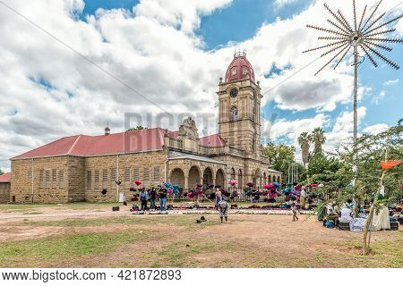 Oudtshoorn, South Africa - April 5, 2021: Vendors With Their Goods, Dusters Made From Ostrich Feathe
